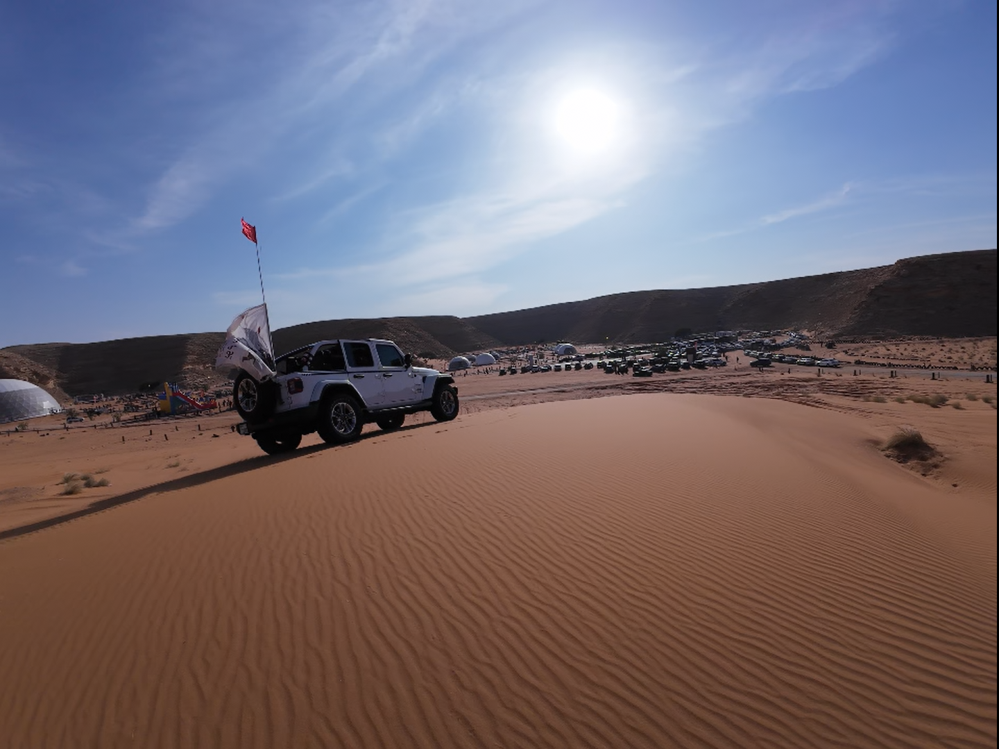 Precision equipment like RTK base stations ensure centimeter-level accuracy for both mapping and live broadcast positioning. A drone RTK base station set up in the Riyadh desert with a drone hovering above at golden hour.
