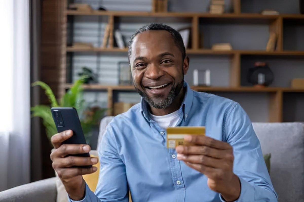 Cybersecurity trends that matter right now: man holding a bank card and smartphone