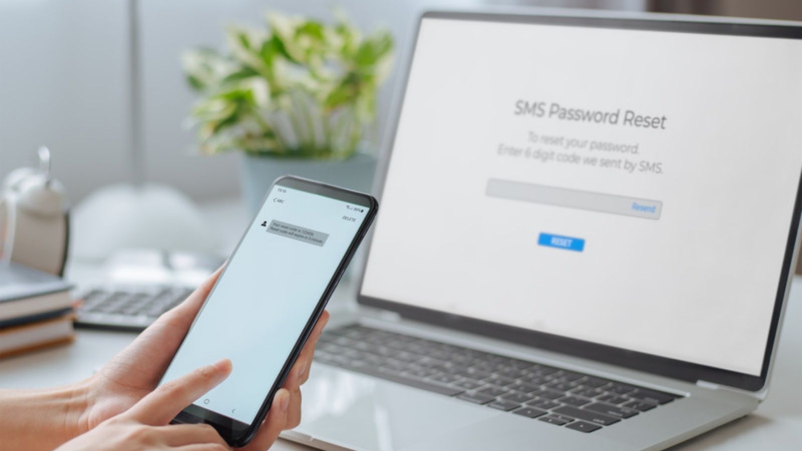 Phone showing a fake text message beside a laptop, The Red Flags I Check For in Every Kind of Scam