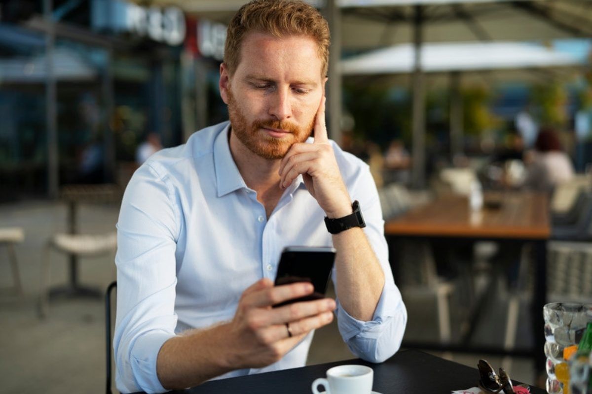 What nearly all scams have in common: worried man reading an urgent message on his phone