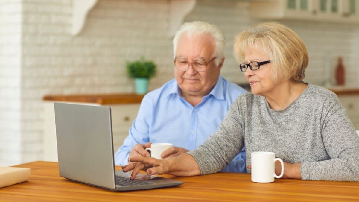 Older couple learning online safety basics together at a laptop