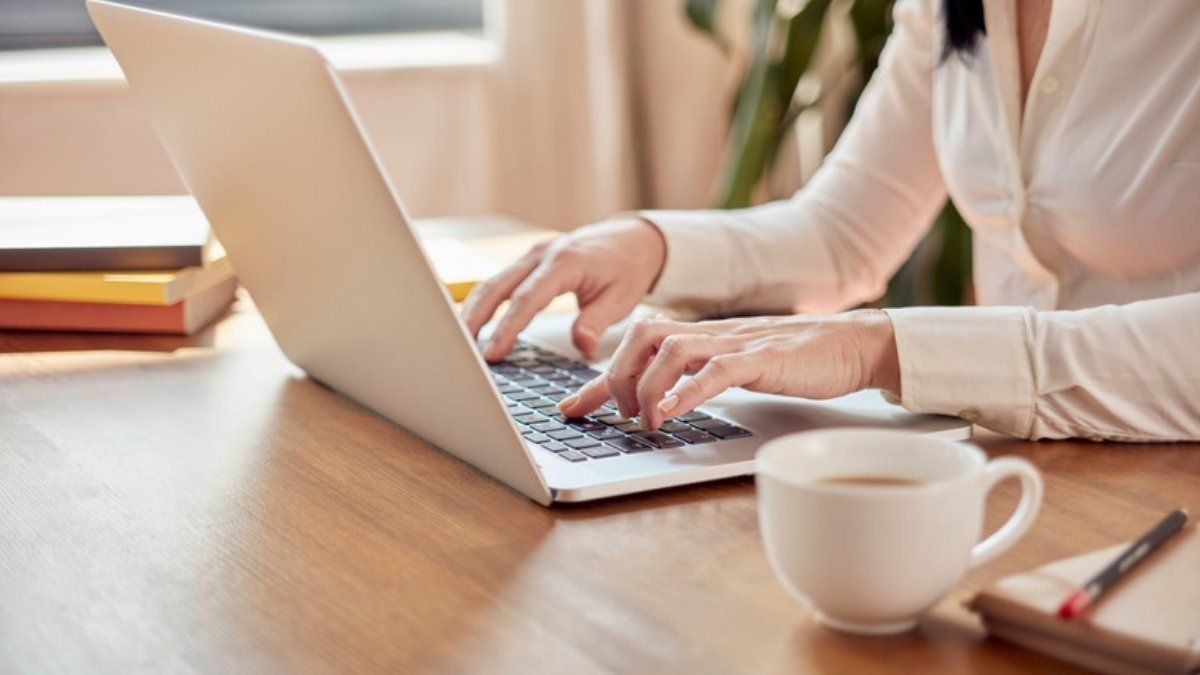 Woman typing on a laptop, representing common password manager myths and how to set one up safely