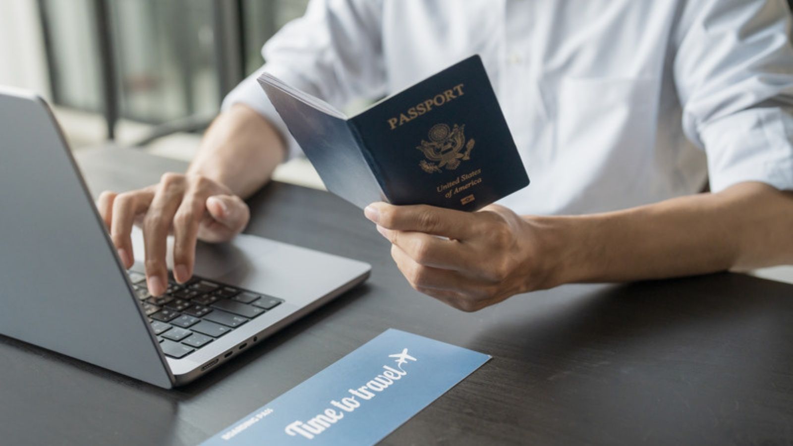 Traveller holding a passport while using a laptop, How to Choose a VPN Service: What I Actually Look For