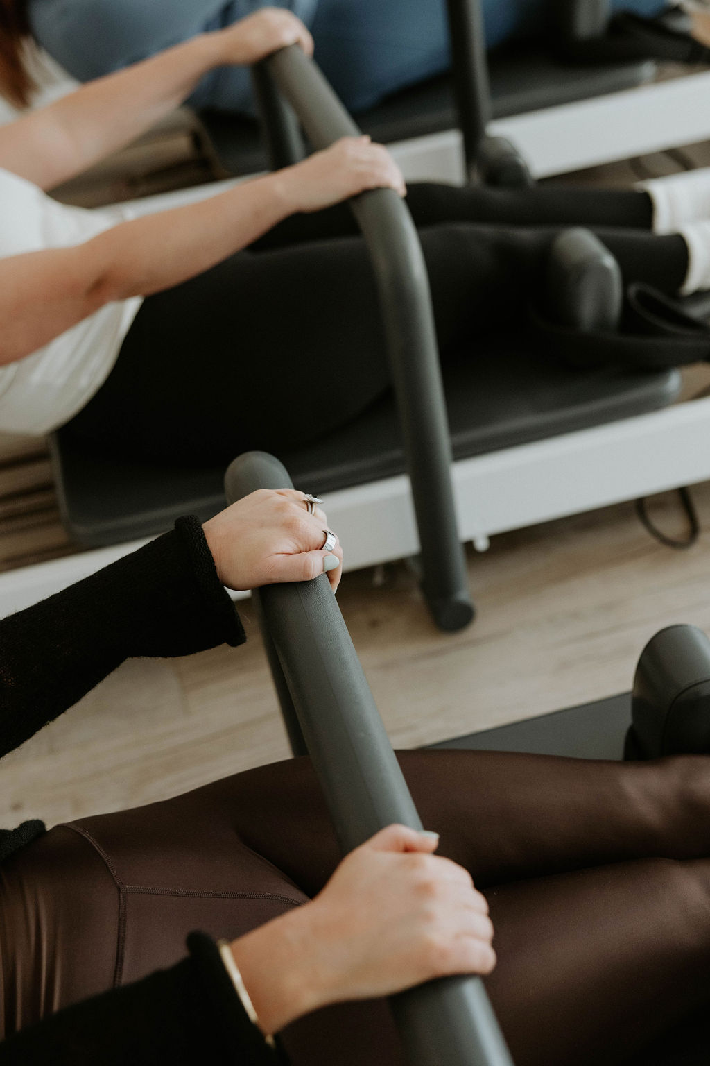 Our dedicated studio spaces in Caringbah and Kensington are designed for focused, mindful practice. Wide shot of the Kensington Pilates studio showing reformers and chairs in a bright, airy environment.