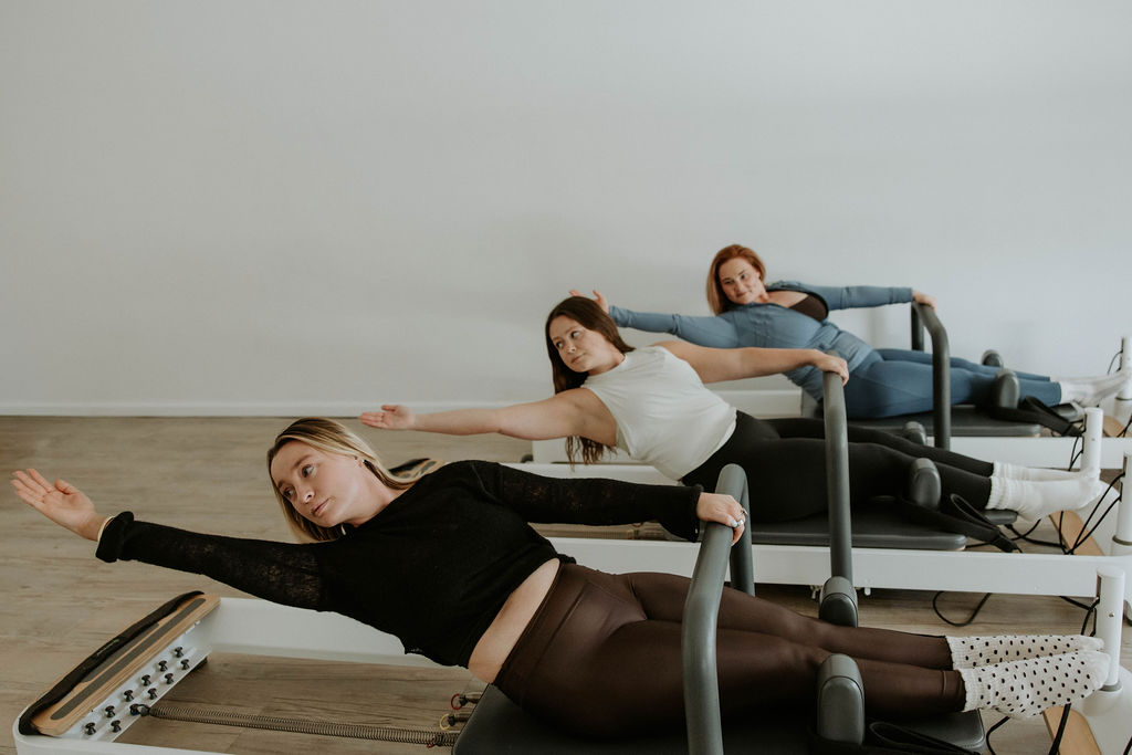 Specialized equipment like the ladder barrel allows for varied resistance and bone loading. A close up shot of a Pilates ladder barrel with pink trim and wooden rungs in a professional studio.
