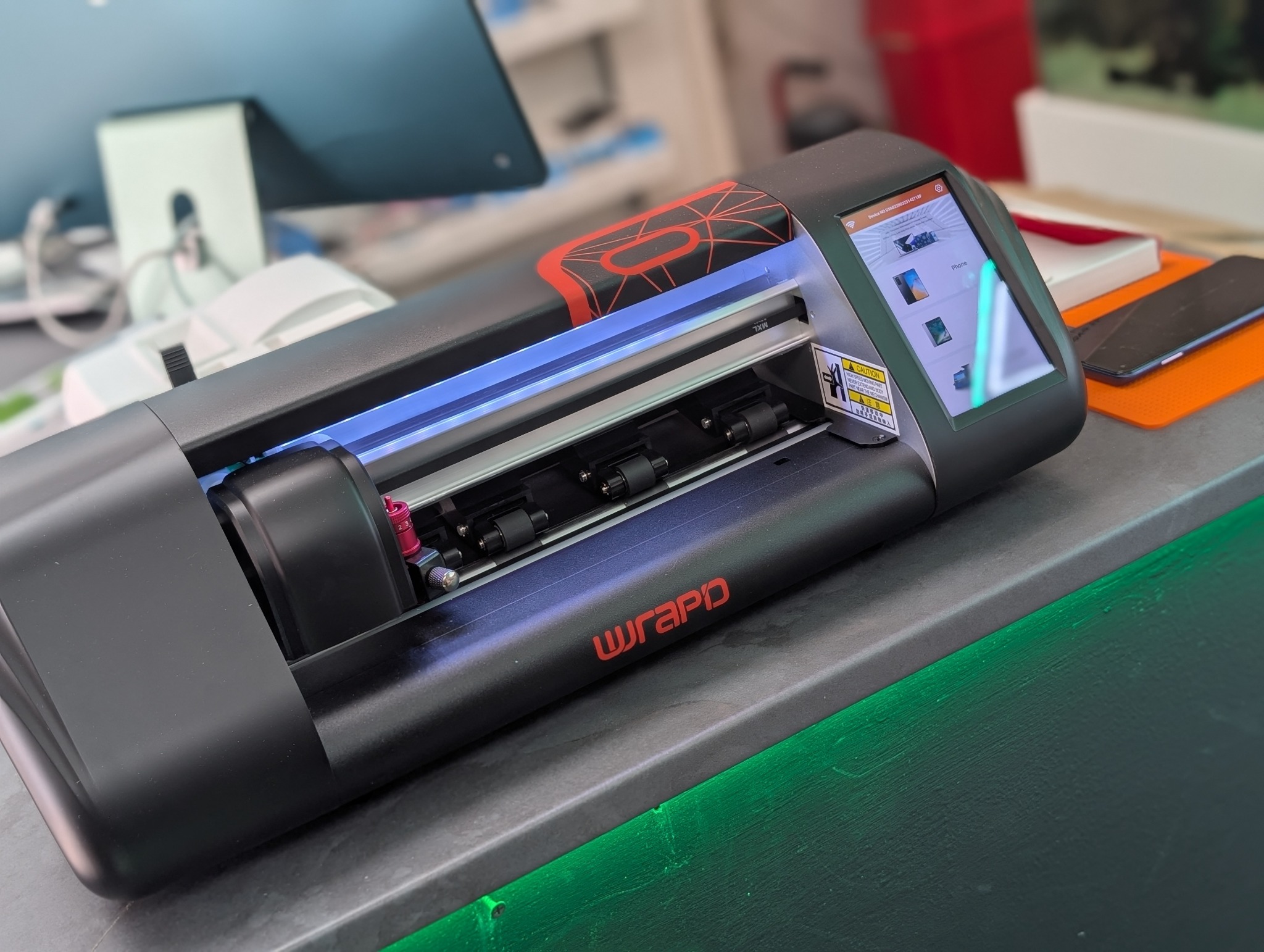 NXT GEN's Wrapd screen protector cutting machine on the counter in our Leigh-on-Sea store